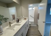 Thumbnail 7 of 39 - a bathroom with white cabinets and a sink and a mirror