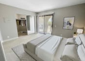 Thumbnail 17 of 39 - a bedroom with a large bed and a sliding glass door
