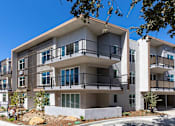 Thumbnail 4 of 28 - A modern apartment building with balconies and multiple stories.