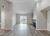 Thumbnail 2 of 14 - an empty living room with a fireplace and a door to a balcony