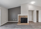 Thumbnail 4 of 14 - an empty living room with a fireplace and grey walls