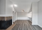 Thumbnail 8 of 14 - an empty living room with a fireplace and a kitchen