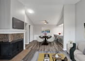 Thumbnail 7 of 14 - a living room with a fireplace and a table with chairs