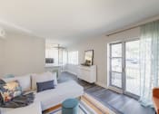 Thumbnail 10 of 24 - the living room and kitchen of a house with large windows