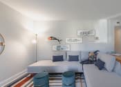 Thumbnail 13 of 24 - a living room with a white couch and a striped rug