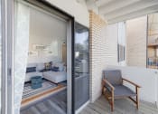 Thumbnail 12 of 24 - a balcony with a couch and a chair and a sliding glass door