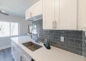 Thumbnail 1 of 24 - a kitchen with white cabinets and a sink