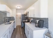 Thumbnail 4 of 24 - a kitchen with white cabinets and stainless steel appliances and a sink