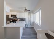 Thumbnail 5 of 24 - a kitchen with white cabinets and a large window and a white counter top