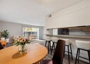 Thumbnail 9 of 27 - A dining room with a wooden table and chairs.