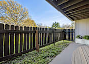 Thumbnail 23 of 27 - A wooden fence with a grey railing and a grey bench.