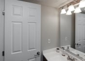 Thumbnail 17 of 35 - a bathroom with a sink and a mirror and a door
