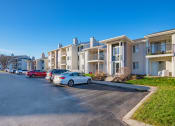 Thumbnail 20 of 35 - a row of apartment buildings with cars parked in front of them
