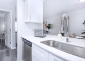 Thumbnail 3 of 35 - a kitchen with a sink and a dishwasher and a door to a living room