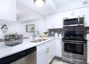 Thumbnail 1 of 35 - a kitchen with stainless steel appliances and white cabinets