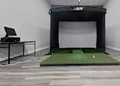 Thumbnail 26 of 35 - A room with a green artificial turf and a black screen.
