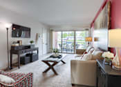 Thumbnail 21 of 39 - Harrisburg Apartment | Twin Lakes Apartments | a living room with a sofa coffee table and a television in front of a sliding glass door