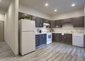 Thumbnail 20 of 20 - Mount Joy Senior Housing | a kitchen with dark cabinets and white appliances