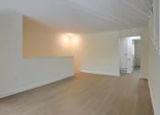 Thumbnail 12 of 39 - A room with wooden floors and white walls.