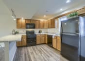 Thumbnail 31 of 51 - Mechanicsburg Apartments | Rockledge Townhomes | a kitchen with wooden cabinets and black appliances