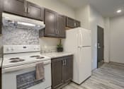 Thumbnail 5 of 20 - Mount Joy Senior Housing | a kitchen with dark cabinets and white appliances