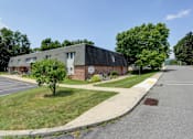 Thumbnail 3 of 15 - a brick building with a black shingled roof