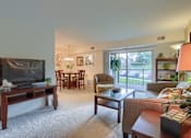 Thumbnail 1 of 13 - Apartments in Harrisburg | Twin Lakes Apartments | a living room with a television and a dining room in the background