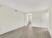 Thumbnail 8 of 39 - A room with light wood flooring and white walls.