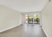 Thumbnail 5 of 39 - A room with a white door and a window with a view of a fence and trees.