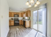Thumbnail 48 of 51 - Mechanicsburg Apartments | Rockledge Townhomes |  a kitchen with wood cabinets and a sliding glass door
