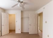 Thumbnail 18 of 20 - A room with a ceiling fan and three doors.