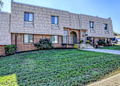 Thumbnail 1 of 10 - A brick house with a green lawn in front.