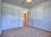 Thumbnail 6 of 10 - A room with white doors and carpeted floor.