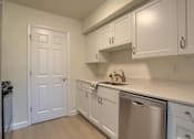 Thumbnail 16 of 39 - A kitchen with white cabinets and a stainless steel dishwasher.
