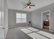 Thumbnail 35 of 37 - a bedroom with a ceiling fan and a doorway into a bathroom | Centerpointe Apartments in Camp Hill