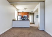 Thumbnail 5 of 18 - an empty living room and kitchen with a counter top and a refrigerator