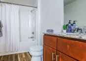 Thumbnail 3 of 18 - a bathroom with a shower and a toilet and a wooden vanity
