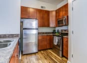 Thumbnail 1 of 18 - a kitchen with stainless steel appliances and wooden cabinets