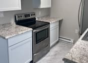 Thumbnail 1 of 23 - A kitchen with white cabinets and granite countertops.