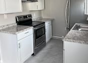 Thumbnail 5 of 23 - A kitchen with white cabinets and a granite countertop.