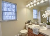 Thumbnail 33 of 51 - Mechanicsburg Apartments | Rockledge Townhomes |a bathroom with a toilet sink and mirror