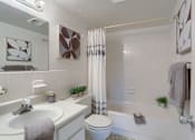 Thumbnail 12 of 13 - Apartments in Harrisburg | Twin Lakes Apartments | a bathroom with a white sink and toilet next to a white bathtub