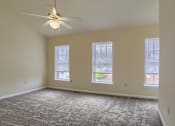 Thumbnail 57 of 58 - A room with a ceiling fan and carpeted floor.