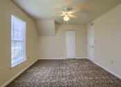 Thumbnail 44 of 58 - A room with a ceiling fan and carpeted floor.