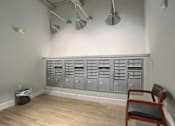 Thumbnail 4 of 20 - Mount Joy Senior Housing | a row of gray metal cabinets and a chair in a room with a hardwood floor