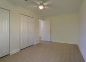 Thumbnail 32 of 39 - A room with a ceiling fan and wooden flooring.