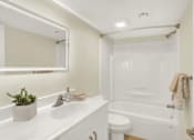 Thumbnail 6 of 39 - A white bathroom with a toilet, sink, and tub.