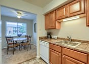Thumbnail 8 of 16 - Mechanicsburg Apartments | Delbrook Manor Apartments | a kitchen with wooden cabinets and a white dishwasher