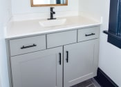 Thumbnail 6 of 26 - a bathroom with white cabinets and a sink and a mirror