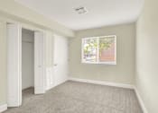 Thumbnail 36 of 39 - A room with a carpeted floor and a window showing a view of a street.